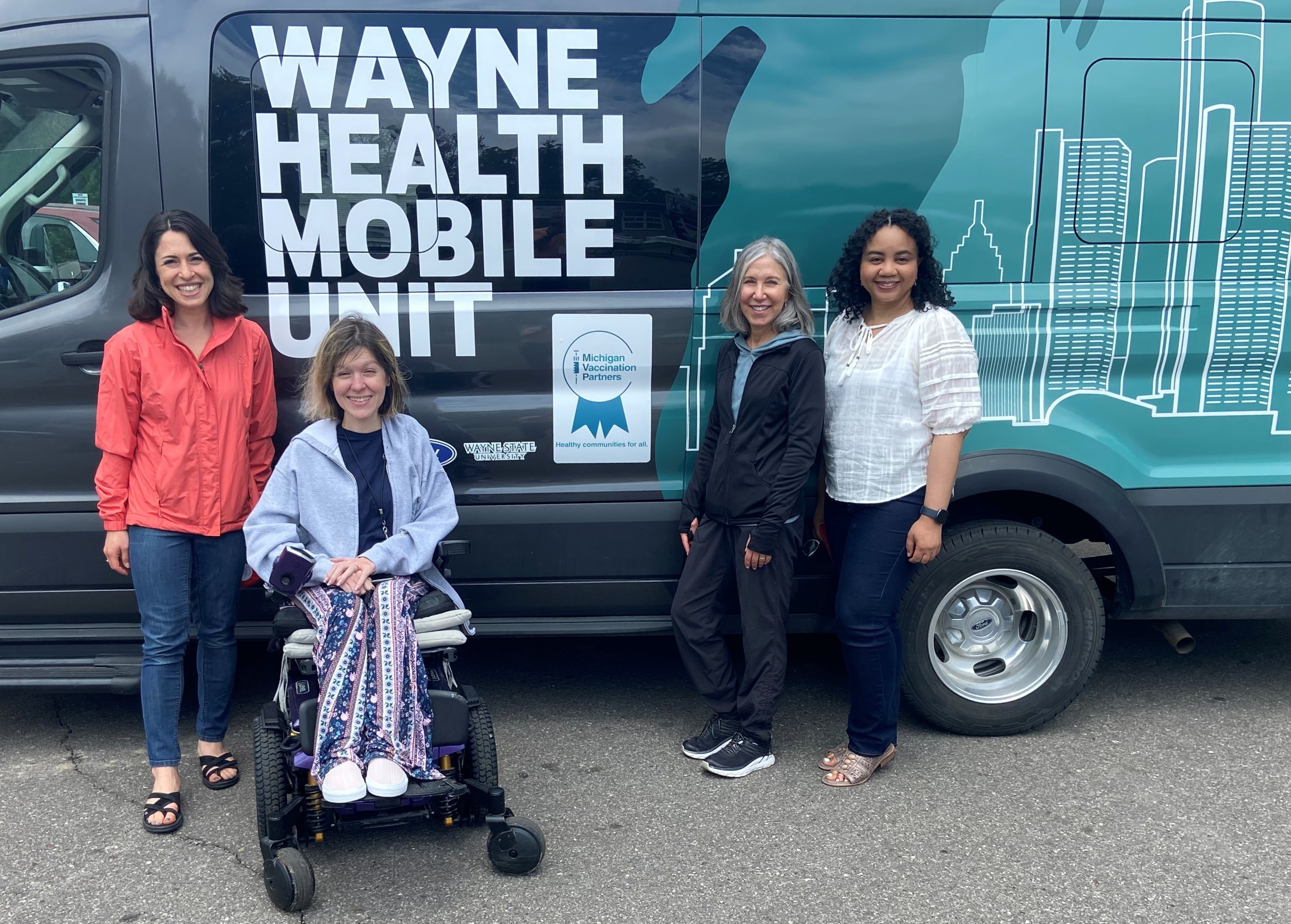 MVP project staff stand next to the Wayne Health Mobile Unit van. The MVP logo is on the van next to the group.