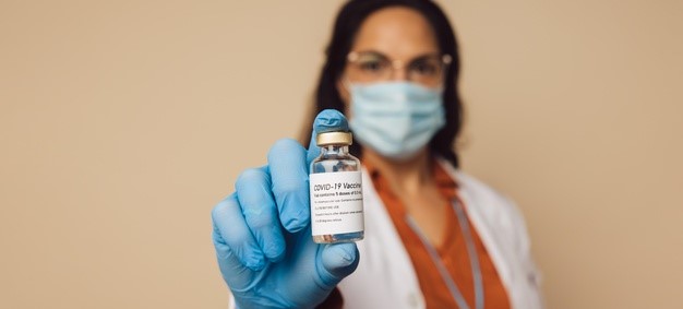 A healthcare worker holding a bottle of COVID-19 vaccine.
